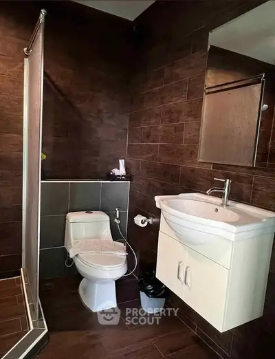 Modern bathroom with sleek dark tiles and contemporary fixtures.