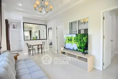 Spacious modern living room with elegant decor and large TV, perfect for relaxation.