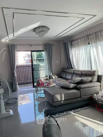 Spacious living room with modern gray sofa and elegant chandelier