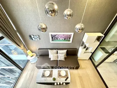 Modern living room with stylish decor and large windows offering city views.