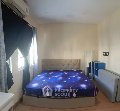 Cozy bedroom with galaxy-themed bedding and ample natural light