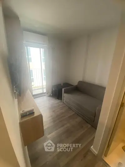 Cozy living room with sofa and balcony view, perfect for urban living.