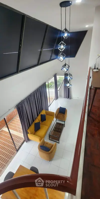 Stunning modern living room with high ceilings, elegant lighting, and large windows offering a bright, airy atmosphere.