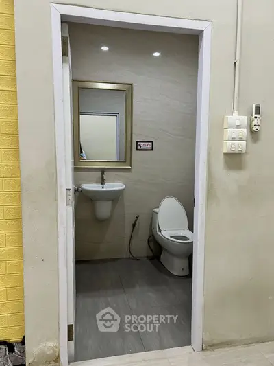Compact bathroom with modern fixtures and wall-mounted sink, ideal for small spaces.