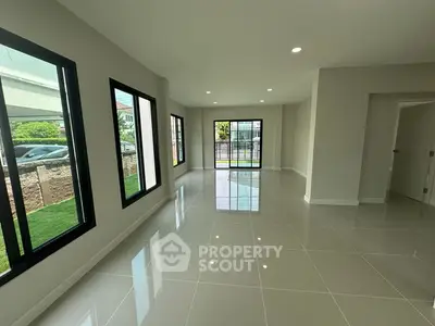 Spacious modern living room with large windows and glossy tiled floors