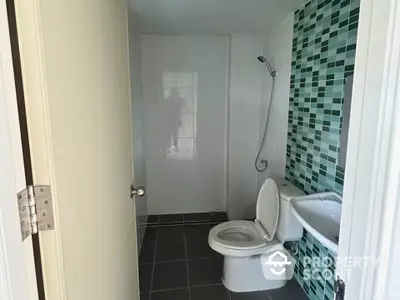 Modern bathroom with stylish green tile accent wall and sleek fixtures