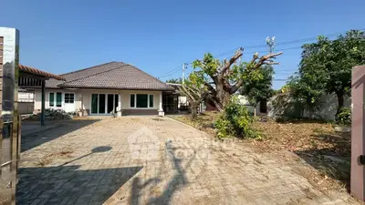 Charming single-story home with spacious driveway and lush garden, perfect for family living.