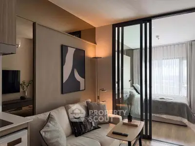 Modern living room with sliding glass doors leading to a cozy bedroom, featuring stylish decor and natural light.