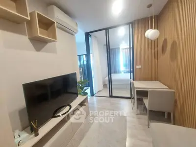 Modern living room with sleek design and open layout, featuring a TV and stylish furniture.