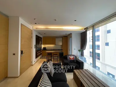 Modern living room with open kitchen and large windows in a city apartment
