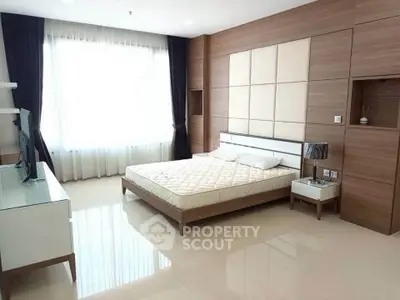 Spacious modern bedroom with large window and stylish decor