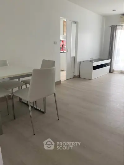 Modern minimalist dining area with sleek white furniture and natural light