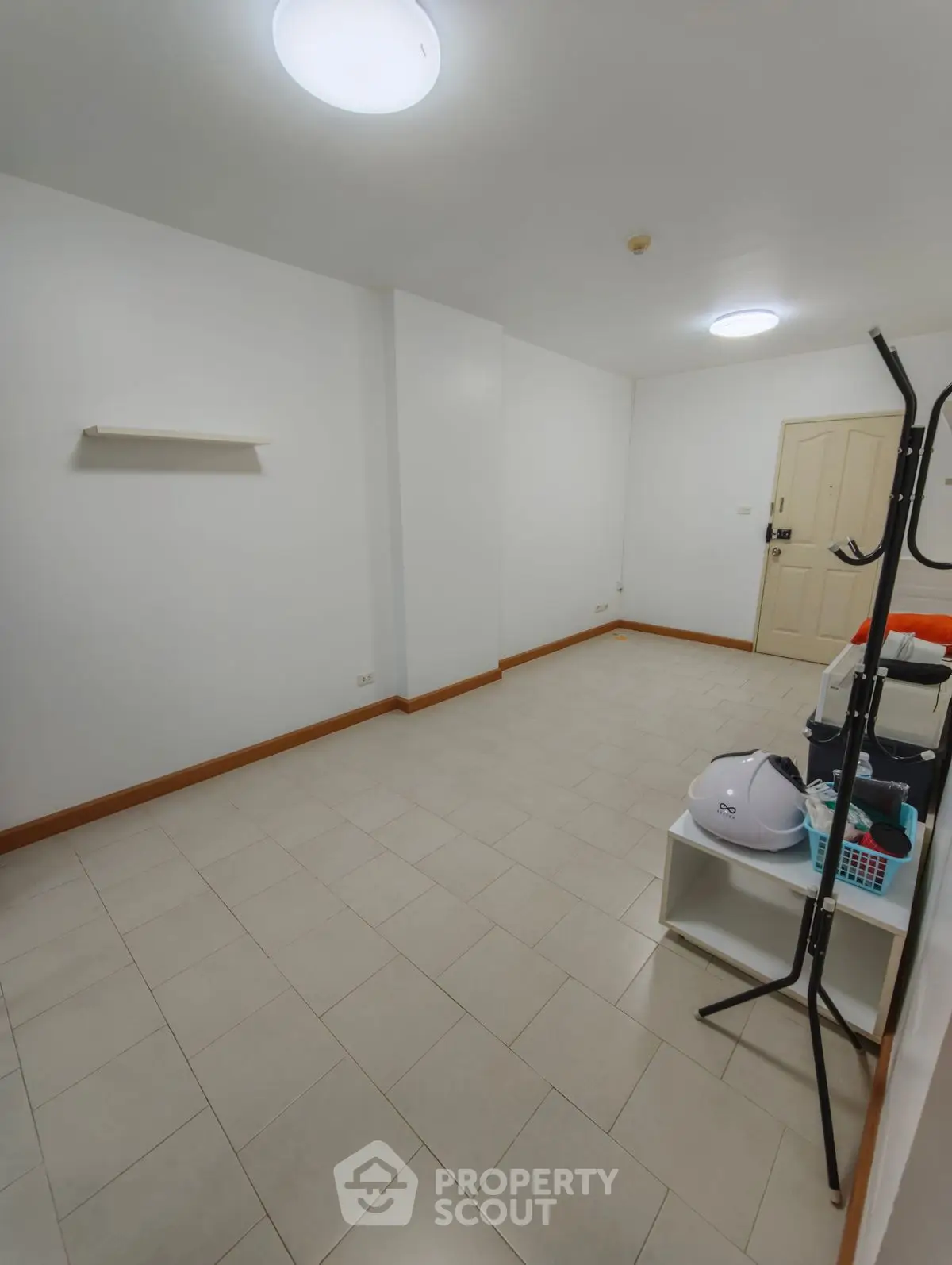 Spacious empty room with tiled floor and white walls, ideal for customization.