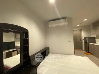 Modern studio apartment with sleek kitchen and cozy sleeping area, perfect for urban living.