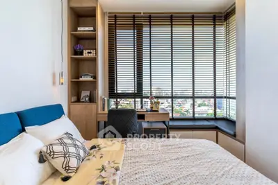Modern bedroom with large windows and stylish decor offering a stunning city view.