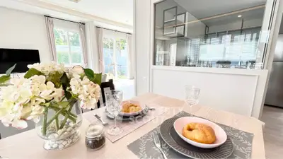 Elegant dining area with modern decor and open kitchen view, perfect for stylish living.