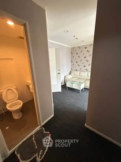 Cozy apartment interior with living room and bathroom, featuring modern decor and comfortable furnishings.