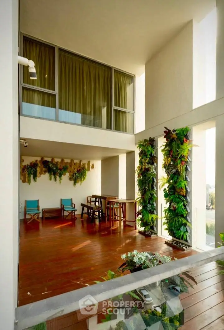 Spacious balcony with lush vertical garden and wooden flooring, perfect for relaxation and entertaining.