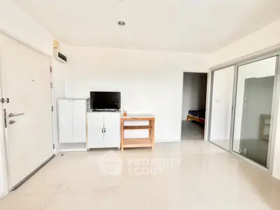 Spacious minimalist living room with TV and sliding glass door