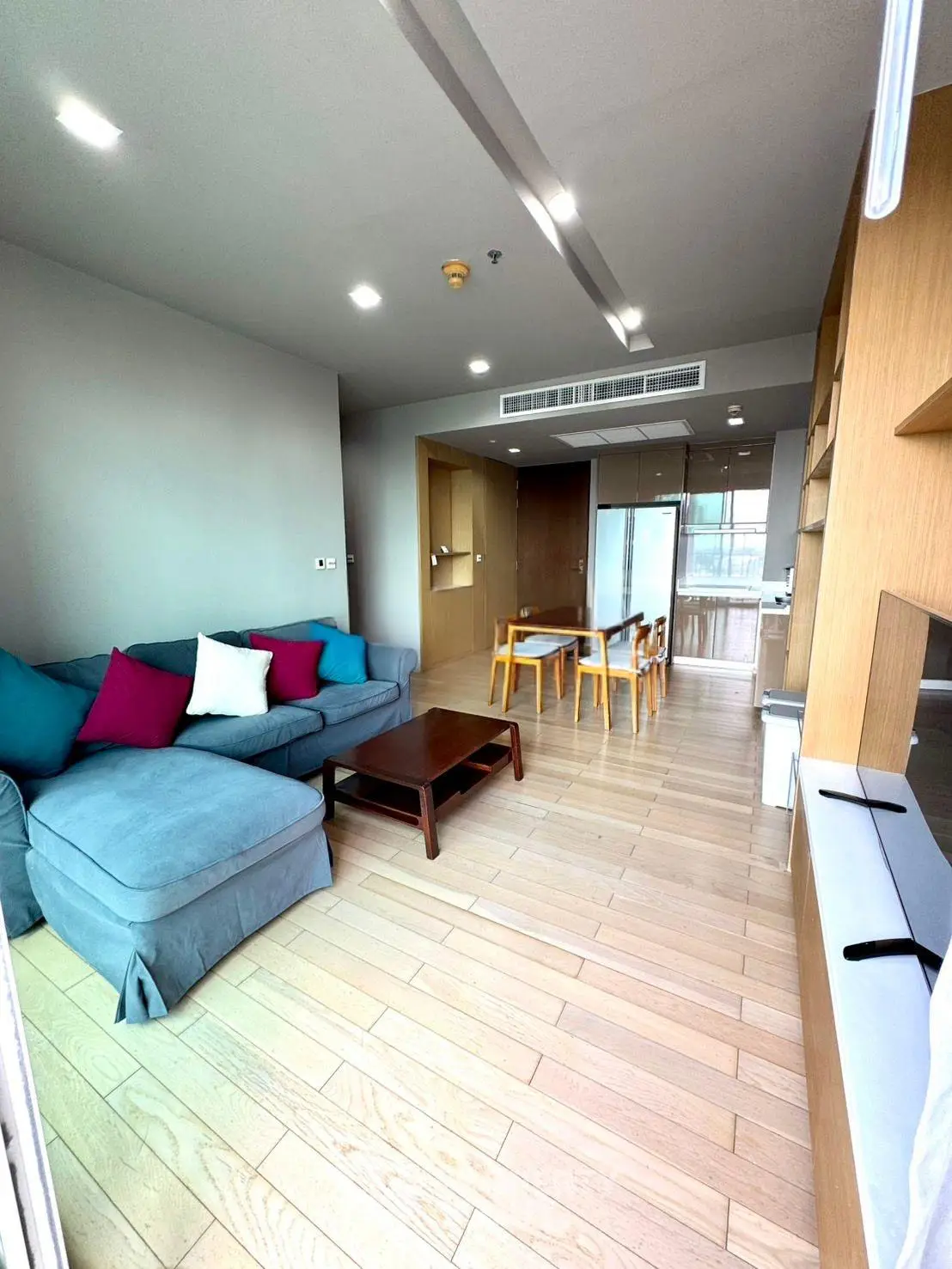 Spacious modern living room with wooden flooring and stylish furniture in a contemporary apartment.