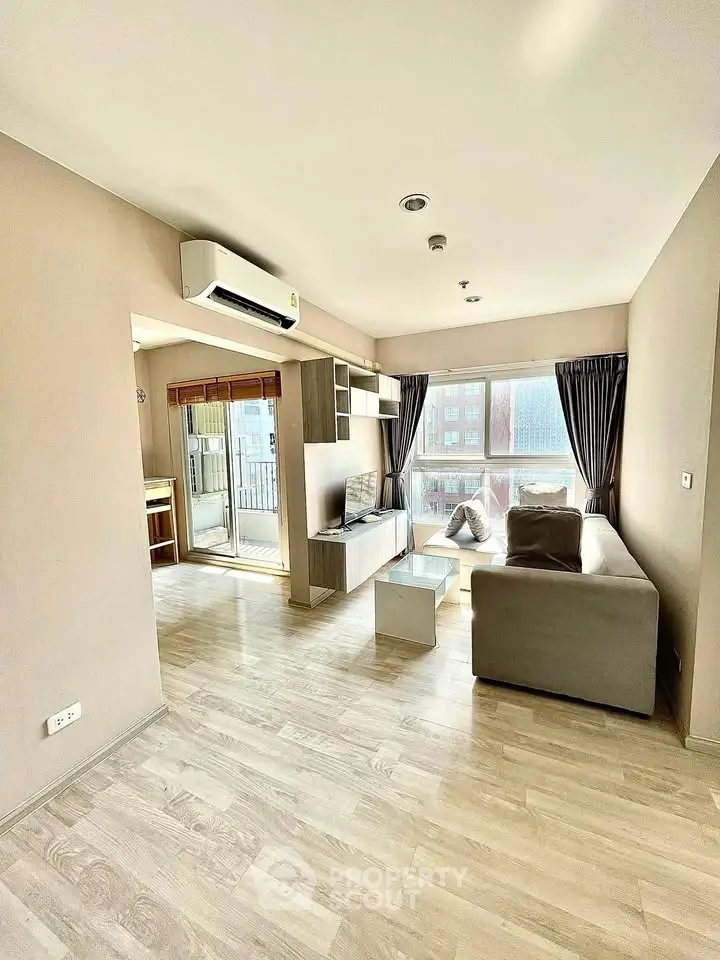 Spacious modern living room with large windows and balcony access in a stylish apartment.