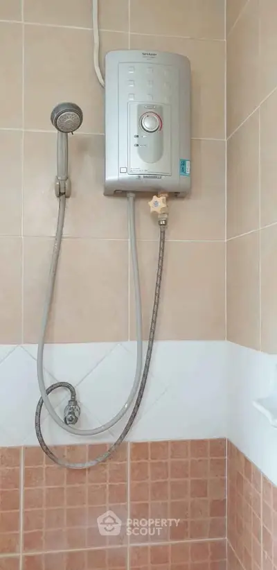 Modern bathroom with electric shower unit and tiled walls