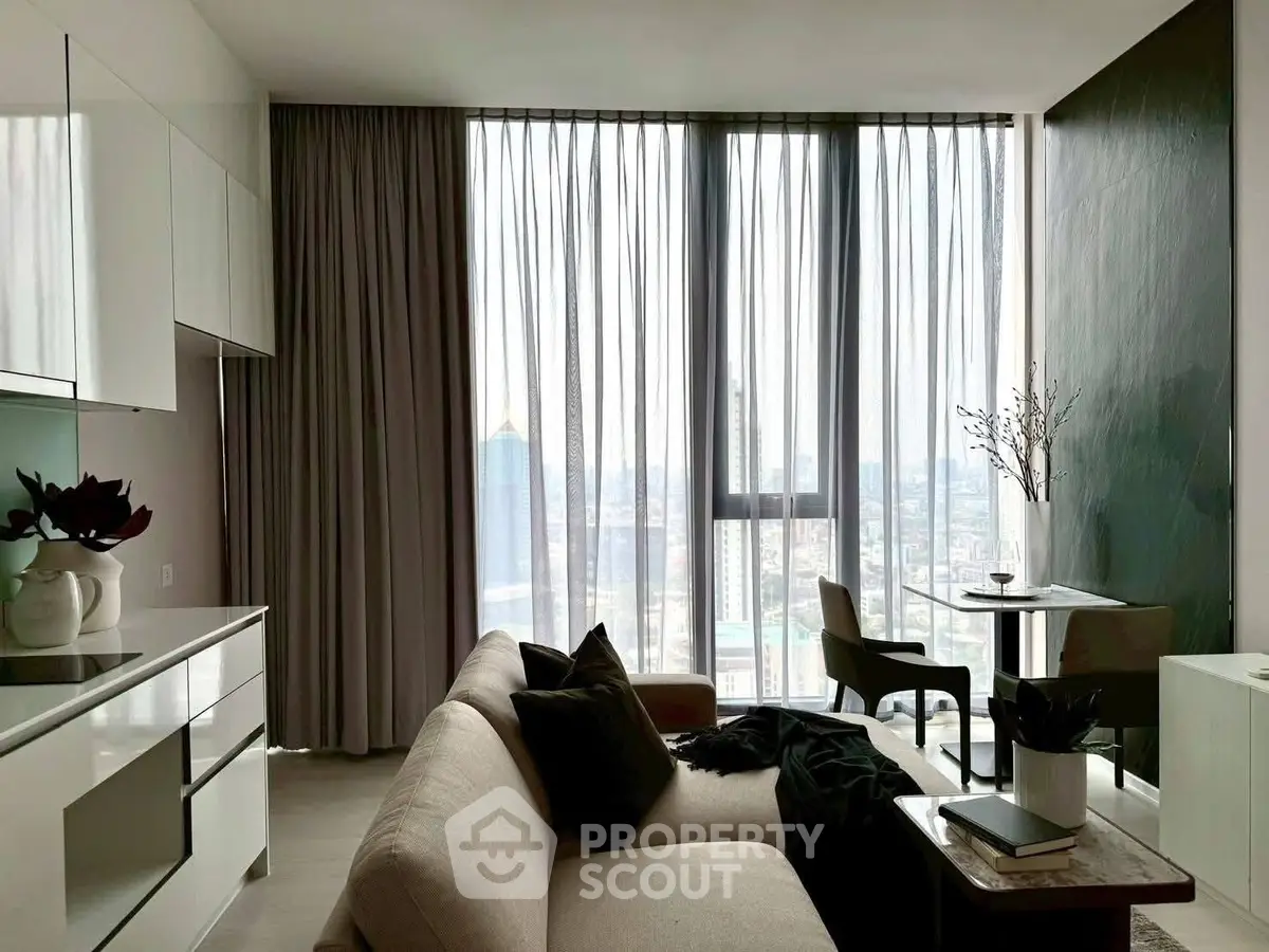 Modern living room with floor-to-ceiling windows and city view, featuring elegant furniture and decor.