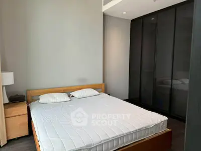 Modern bedroom with sleek design and ample storage in a stylish apartment.