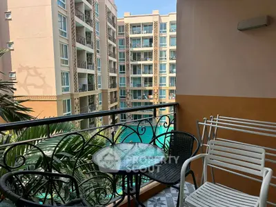 Charming balcony view overlooking a luxurious pool in a modern apartment complex.