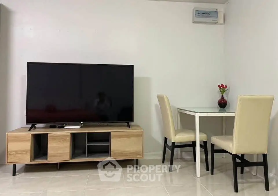 Modern living room with sleek TV stand and cozy dining area, perfect for urban living.