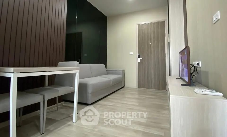 Modern living room with sleek furniture and wooden flooring in a stylish apartment.