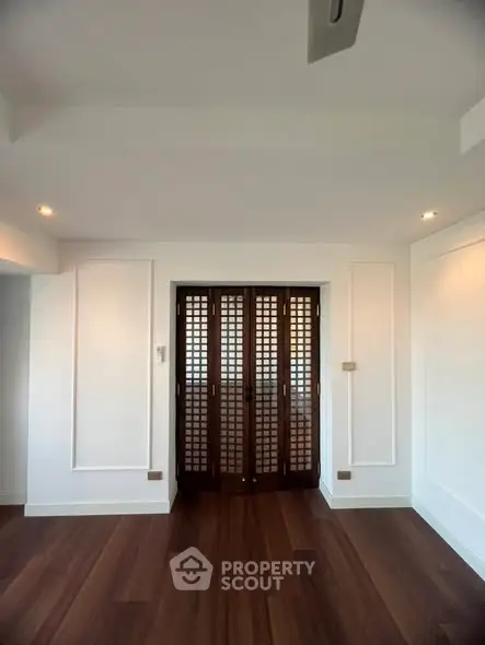 Spacious interior with elegant wooden flooring and stylish panel doors