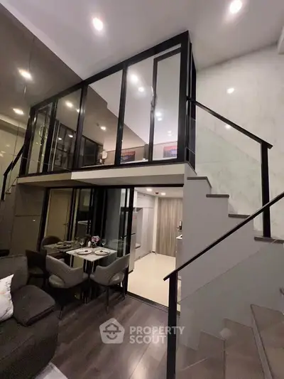 Modern duplex interior with stylish glass walls and elegant staircase