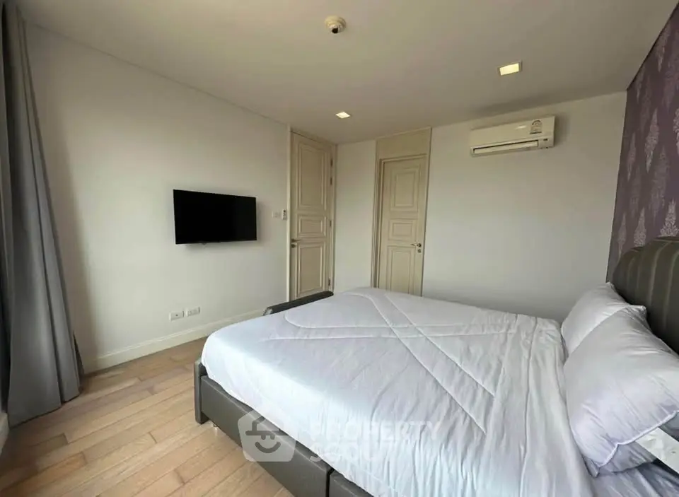 Modern bedroom with sleek design, featuring a wall-mounted TV and air conditioning for ultimate comfort.