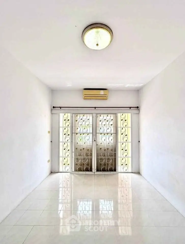 Bright and spacious room with elegant metal door and air conditioning, perfect for modern living.