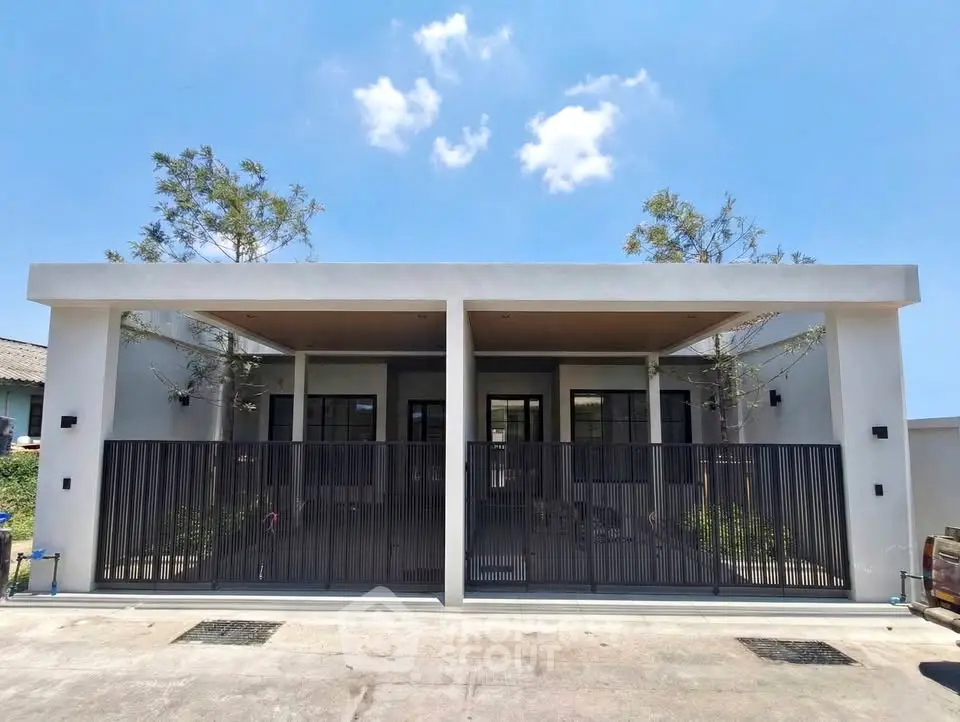 Modern minimalist house exterior with sleek design and spacious driveway under clear blue sky.