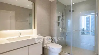 Modern bathroom with glass shower and sleek vanity in luxury apartment.