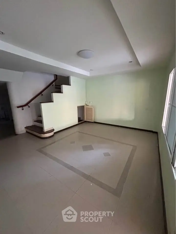 Spacious living room with modern staircase and natural light