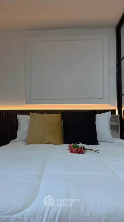 Cozy bedroom with elegant decor and soft lighting, featuring a neatly made bed with stylish pillows.