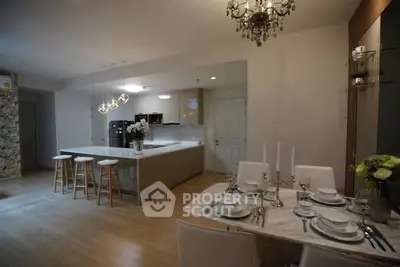 Elegant open-layout kitchen and dining area with modern lighting and decor