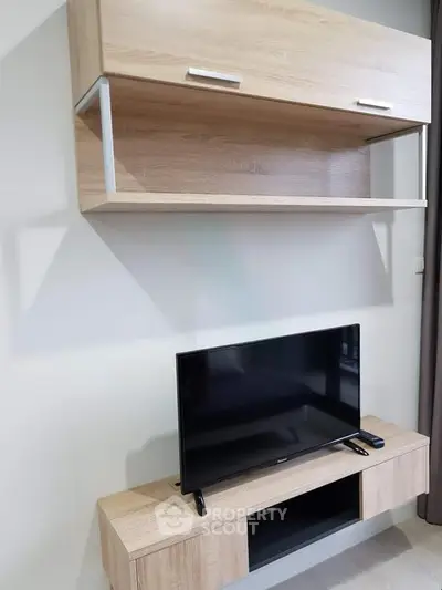 Modern living room with sleek wooden TV stand and wall-mounted cabinet