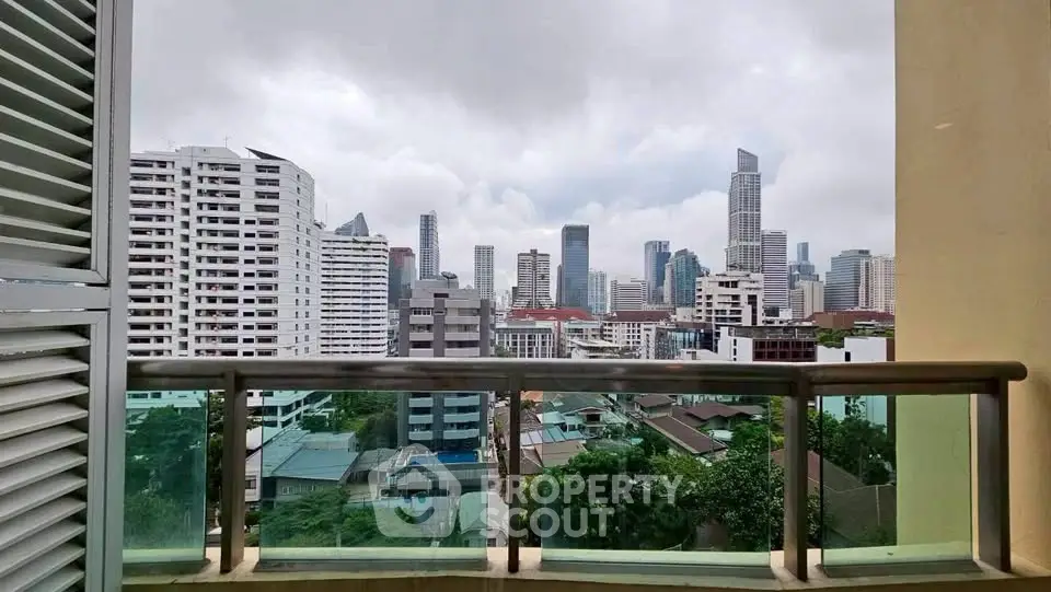 Stunning cityscape view from a high-rise balcony in a vibrant urban setting.