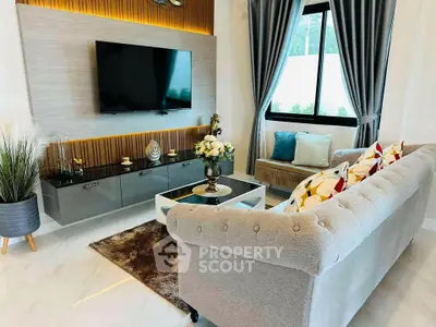 Elegant living room with modern decor, plush sofa, wall-mounted TV, and stylish accents.