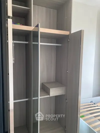 Spacious modern wardrobe with sleek wooden finish and ample storage space.