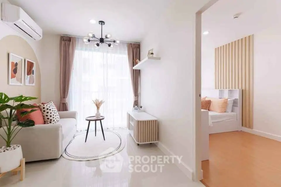 Modern living room with stylish decor and natural light, adjacent to cozy bedroom.