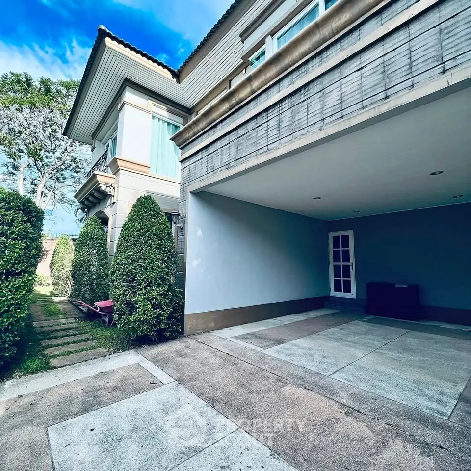 Elegant suburban home with spacious driveway and lush greenery, perfect for family living.