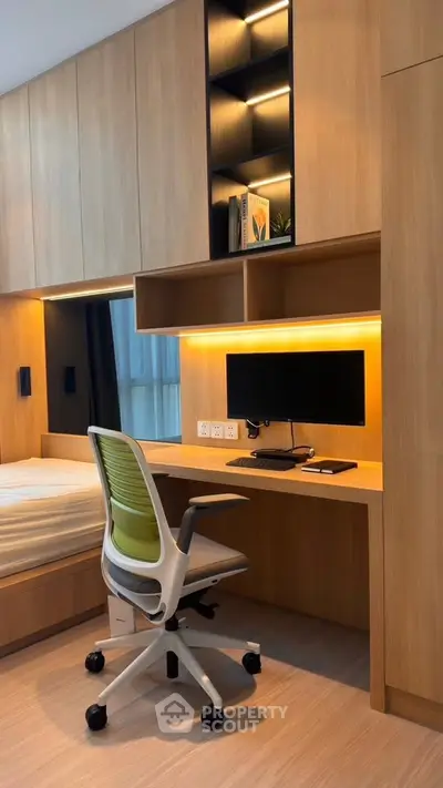 Modern study room with built-in desk, shelving, and ergonomic chair in stylish apartment.