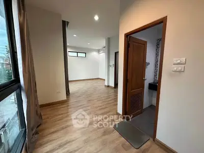 Spacious open-plan living area with wooden flooring and large windows
