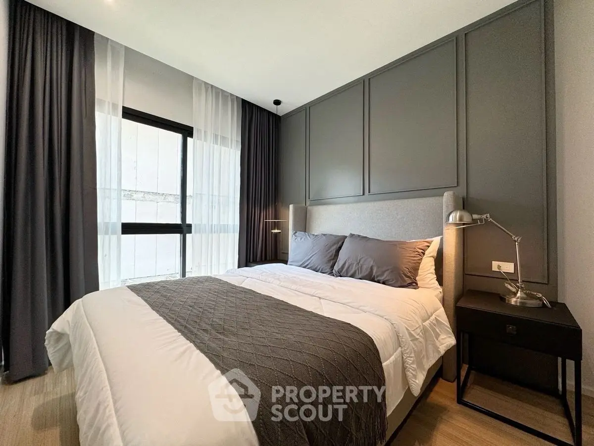 Modern bedroom with elegant decor and large window for natural light.