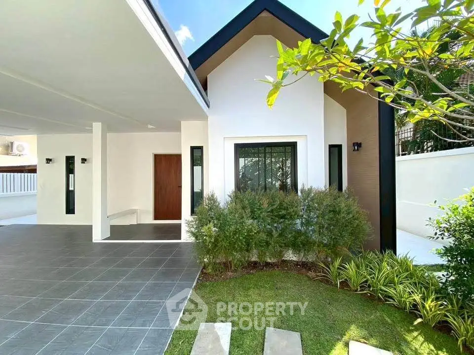 Modern single-story home with spacious carport and lush garden